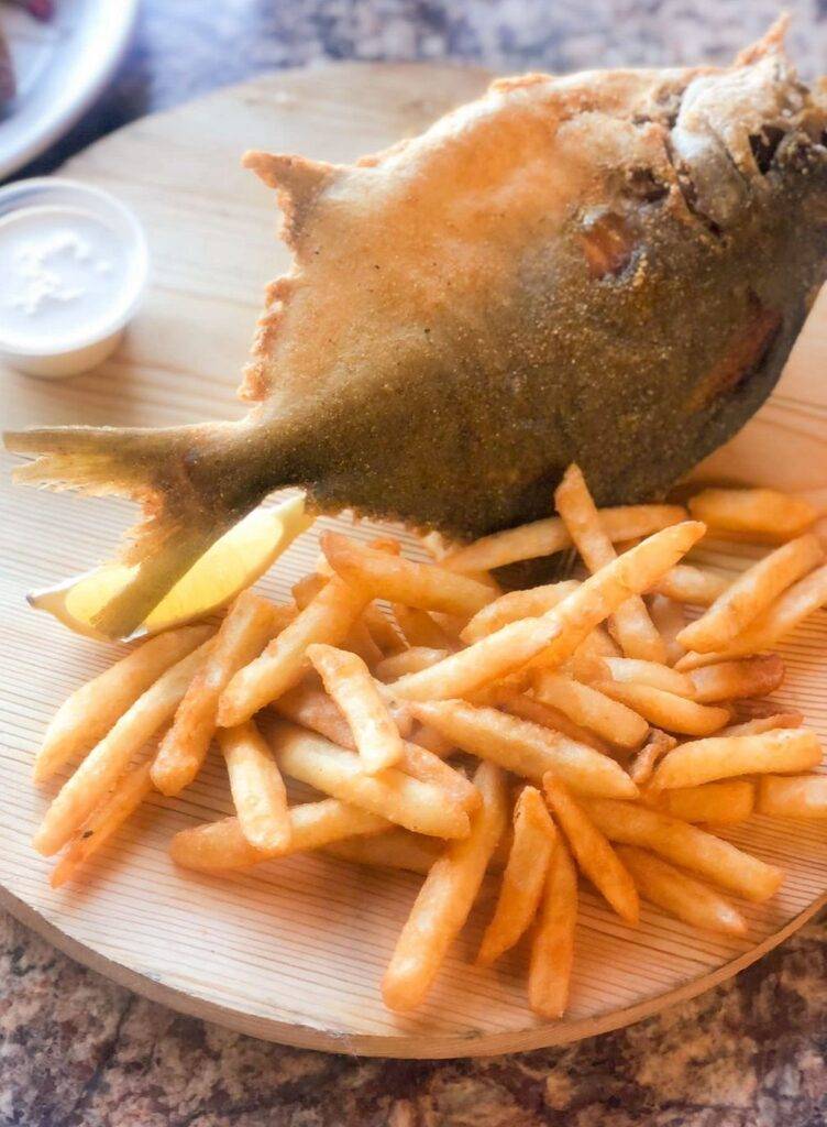 Aliz Seafood & Grill A serving of French fries and a whole fried fish with a lemon wedge on a wooden plate, next to a cup of sauce, is beautifully presented at Aliz_Seafood_Grill_House_. Dearborn MI Aliz Seafood & Grill A serving of French fries and a whole fried fish with a lemon wedge on a wooden plate, next to a cup of sauce, is beautifully presented at Aliz_Seafood_Grill_House_. Dearborn MI