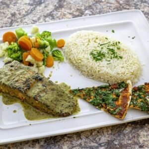 A healthy Mediterranean meal from Dearborn, featuring a white plate with rice and a piece of fish on it.